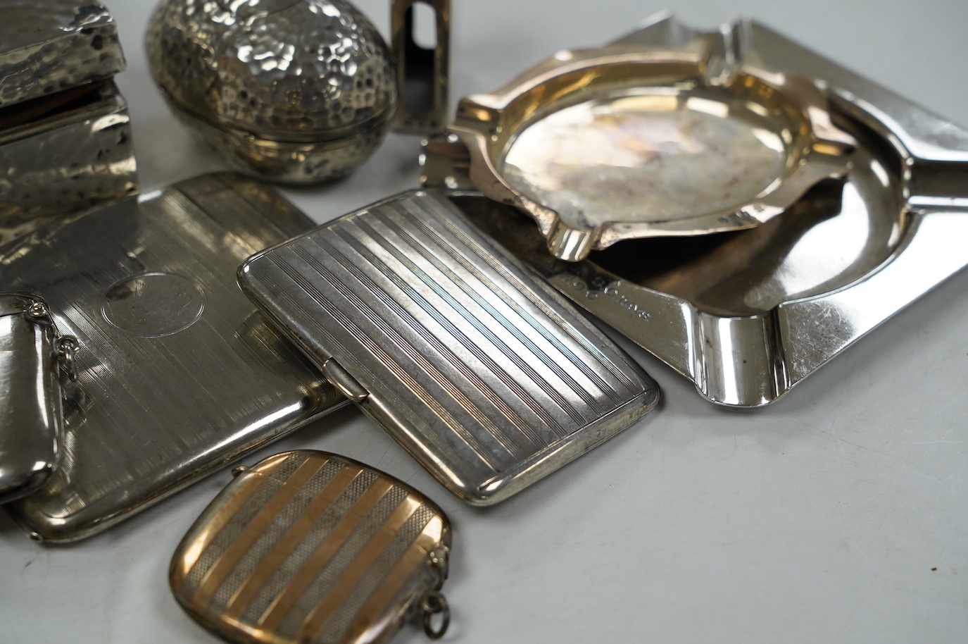 Eleven smoking related items including four silver vesta cases, one egg shaped, two silver ashtrays, two silver cigarette cases, a cigarette box, silver match sleeve and a silver plated Dunhill lighter. Condition - poor